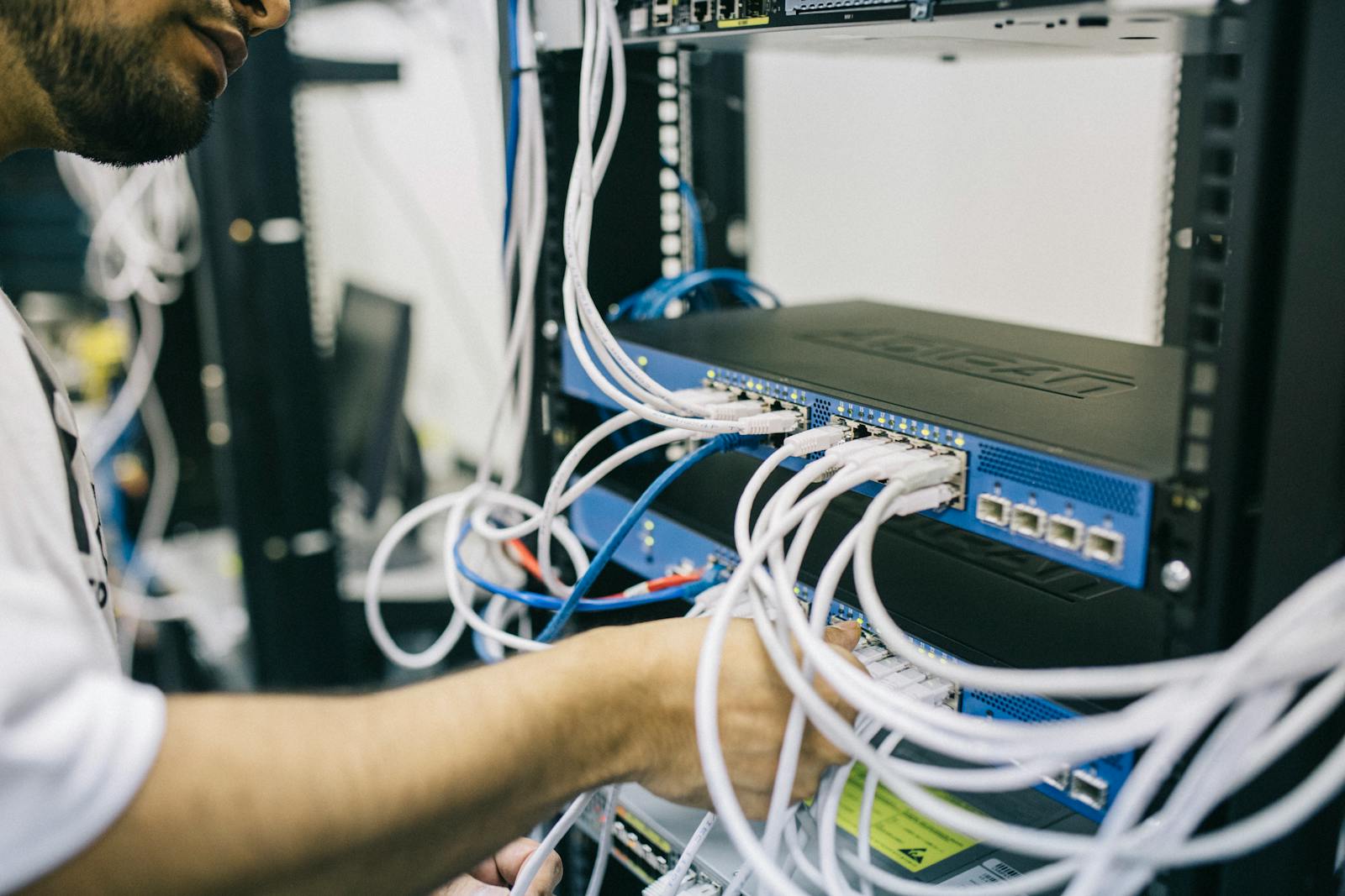 Técnico manuseando módulo de equipamento de rede